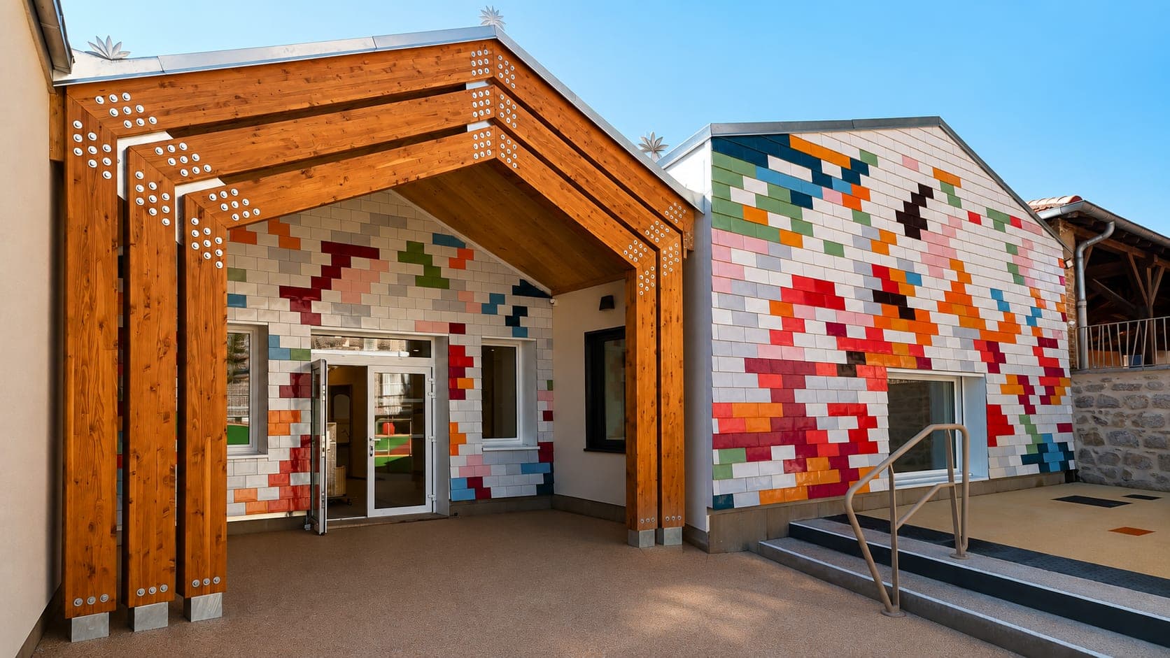 Accueil de loisirs de Renaison : portique en bois lamellé-collé et façade en bardage coloré