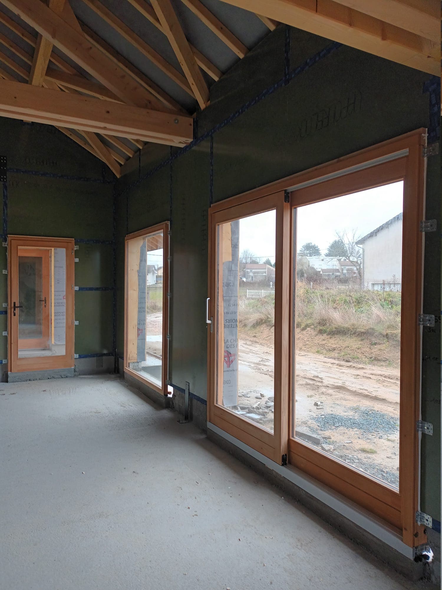 Baie vitrée coulissante en bois dans une maison ossature bois à Montbrison