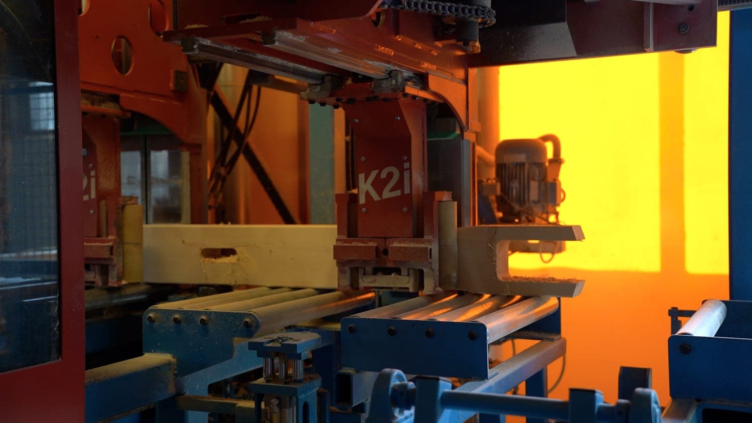 Le centre de taille à commande numérique Hundegger K2i en train de tailler une pièce de charpente dans notre atelier